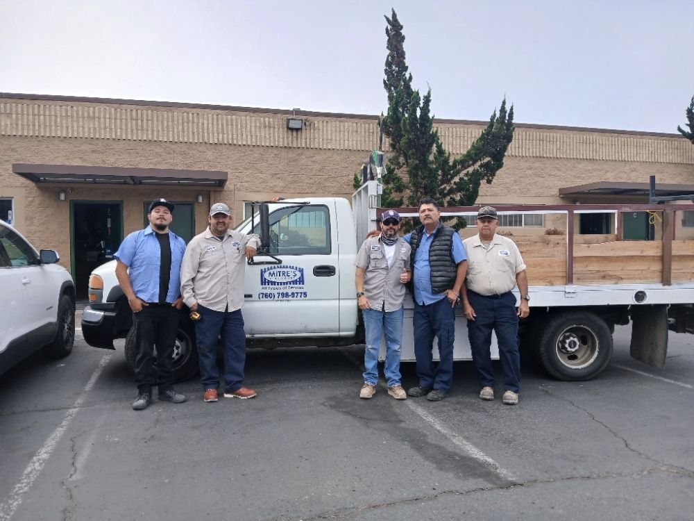 The Mitre's Fence crew with their work trucks at the San Marcos shop