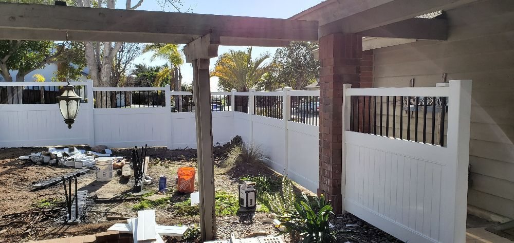 White vinyl privacy fence combined with iron accent panels